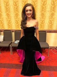 a young woman in a black gown posing in a room