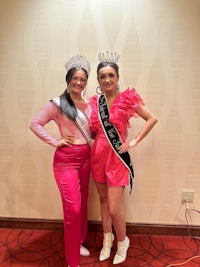 two women posing for a picture in a room