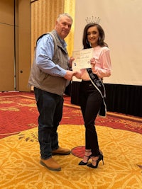a man and woman standing next to each other holding a certificate