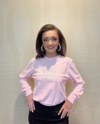 a woman wearing a pink long - sleeve t - shirt