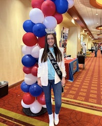 a woman posing in front of a red, white and blue balloon