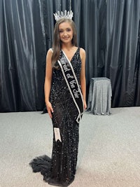 a young woman in a black dress is posing for a picture