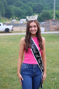 a young woman in a sash posing for a picture